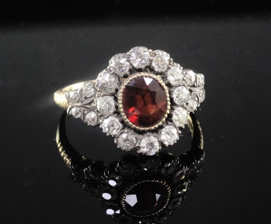 A late Victorian gold and silver, garnet and old cut diamond oval cluster ring, size R.